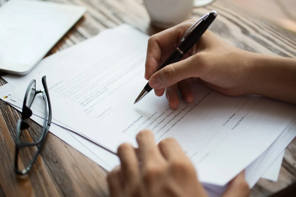 person signing employment contract with pen