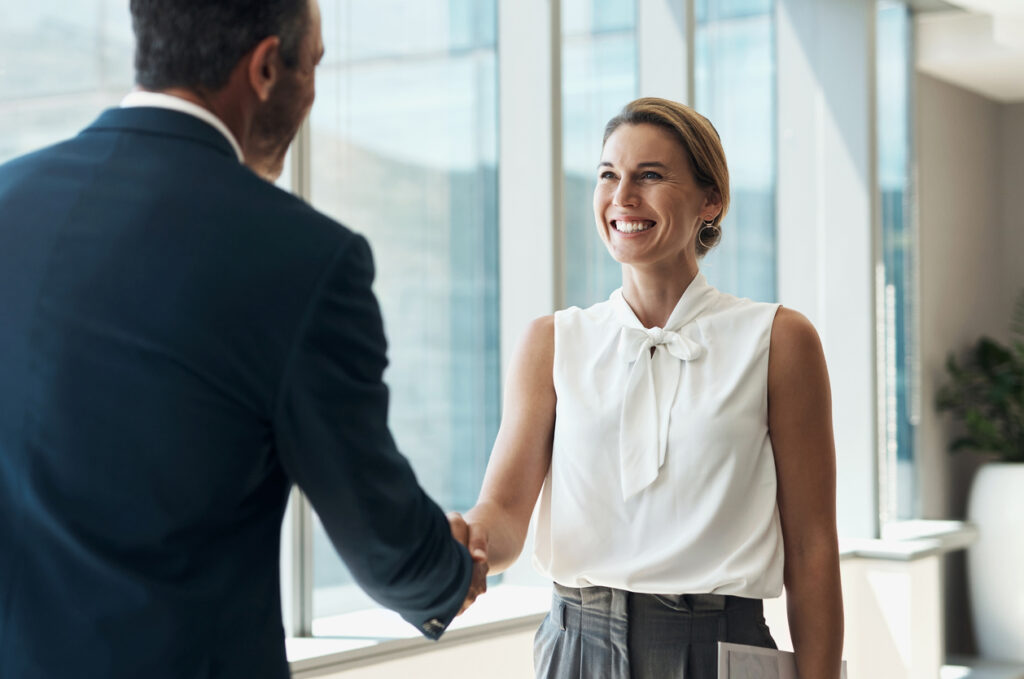 woman shaking hands holding contract of employment